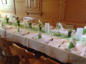 德意志兰茨贝格Bio - Hotel - Alpengasthof Koralpenblick的一张长桌,配有白色桌布和绿色餐巾