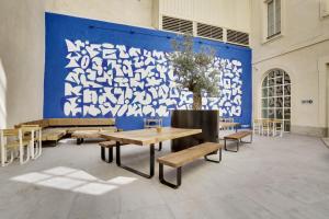 马赛The People - Marseille的一张大蓝色的墙壁,里面设有桌子和长凳