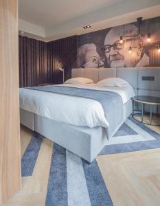 奥斯坦德奥斯坦德酒店的一间卧室配有一张大床和一张男士海报