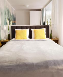 格但斯克Old Motława Mirror Apartment的一间卧室配有一张带黄色枕头的大床