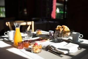 圣维然德Hôtel Restaurant Le Moulin de Saint Verand的一张桌子,上面放着一盘食物和一瓶果汁