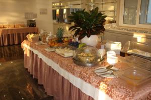 莫尼加Front Lake Hotel Villa Paradiso Suite的厨房里摆放着食物的桌子