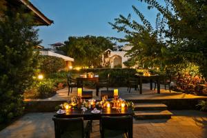达博利The Fern Samali Resort的庭院在晚上配有桌椅