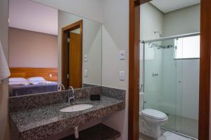 卡皮托利乌玛德米娜斯民宿的一间带水槽、卫生间和淋浴的浴室