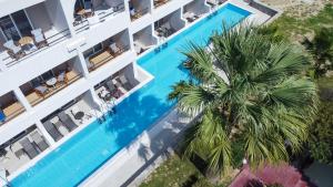 拉多斯Lardos Bay Hotel的享有酒店高处的景致,设有游泳池和棕榈树