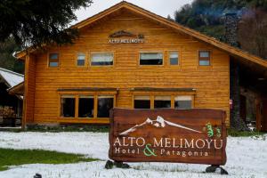 La JuntaAlto Melimoyu Hotel & Patagonia的一座原木建筑,前面有标志