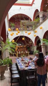 埃尔富埃尔特Hotel Santa Elena的餐厅的长桌,天花板上有橙子