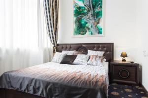哈尔科夫Sumskaya Apartment Lux的卧室配有一张床,墙上挂有绘画作品