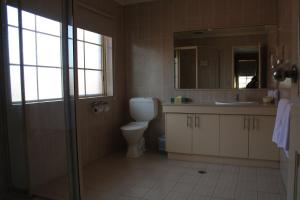 昆比恩格兰德马诺汽车旅馆的一间带卫生间、水槽和镜子的浴室