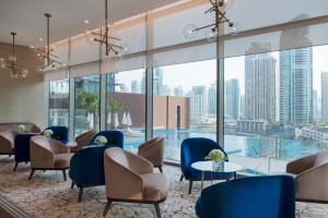 迪拜Jumeirah Living Marina Gate Dubai的酒店大堂设有桌椅和游泳池