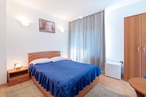 布拉索夫Casa Din Noua的一间卧室配有一张蓝色的床和一张桌子