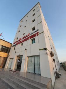 RumaysAl Basateen Hotel Rumays的建筑的侧面有标志