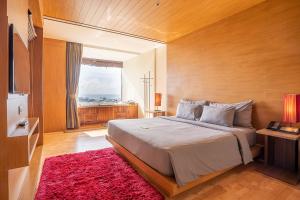芭东海滩The Senses Resort & Pool Villas - SHA Plus的一间卧室配有一张大床和红色地毯。