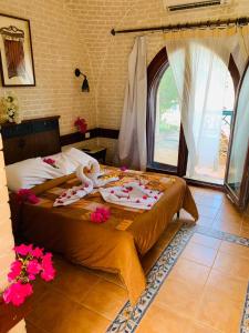 达哈布奈斯玛度假村的一间卧室,床上放着鲜花