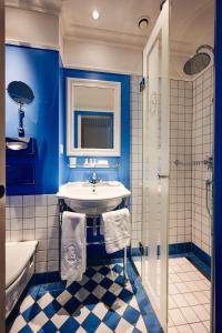 苏黎世Hotel Europe的蓝色的浴室设有水槽和浴缸。