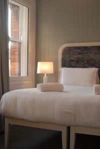 科克Hotel Isaacs Cork City的一间卧室配有一张带灯和窗户的床