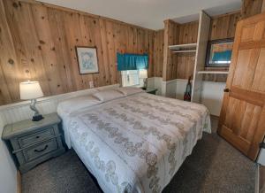 巴克斯顿Outer Banks Motel - Village Accommodations的一间卧室设有一张床和木墙