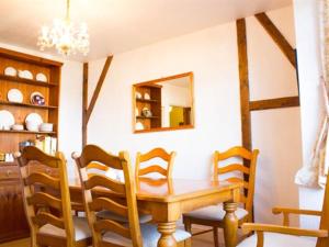 埃文河畔斯特拉特福Moss Cottage的一间带木桌和椅子的用餐室