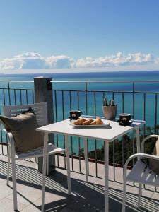 里奥马哲雷都耶洁美利酒店的阳台上配有白色的桌椅,享有海景