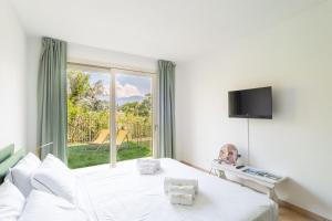 特雷梅佐Como Lake Nest - Studio with garden的白色的卧室设有床和窗户