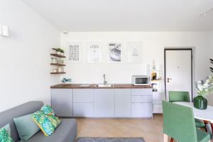 特雷梅佐Como Lake Nest - Studio with garden的厨房以及带沙发和桌子的客厅。