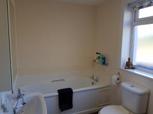 Saint MarysGlenduron-by-Sea的白色的浴室设有浴缸和卫生间。