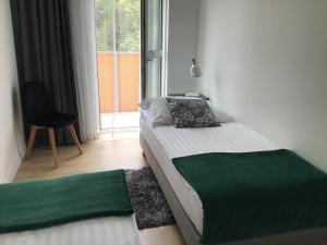 托伦Apartament Avanti z Klimatyzacją i Garażem的卧室配有床、椅子和窗户。