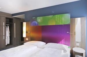 安特拉格里伊格里湖商务酒店的一间卧室配有一张位于楼上的大屏幕床