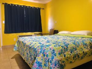 奥克兰海军准将汽车旅馆的黄色客房的一间卧室配有一张床,设有窗户