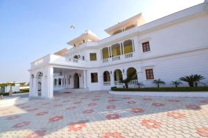 斋浦尔Umaid Farm Resort- A Legancy Vintage Stay In Jaipur的大型白色房屋,设有大型庭院