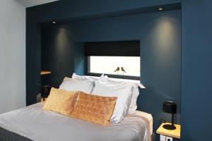 沃德里赫姆Hoeve Altena Cottage的蓝色卧室配有带白色枕头的床