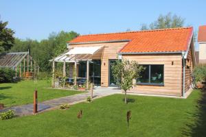 沃德里赫姆Hoeve Altena Cottage的庭院中一座带橙色屋顶的木屋