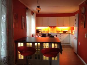 康斯博Sleep well 1的厨房设有红色的墙壁和一张红色凳子的桌子