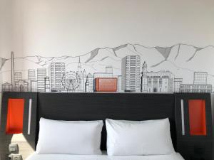 马拉加easyHotel Malaga City Centre的墙上挂着城市壁画的卧室