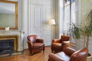 里昂瓦贝库酒店的客厅配有两把椅子和壁炉