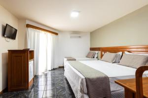 伊瓜苏坎兹卡塔拉塔斯酒店的酒店客房设有两张床和电视。