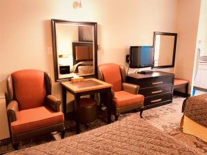卡尔加里红地毯汽车旅馆的酒店客房设有两把椅子和电视