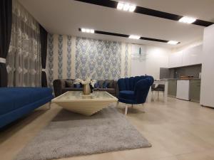 兹拉蒂博尔Zlatibor Hills PRESIDENT的客厅配有沙发、桌子和蓝色椅子
