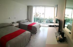 阿卡普尔科阿尔普尔科华美达酒店的酒店客房设有两张床和大窗户。