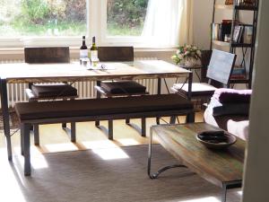 阿尔特瑙Ferienwohnung am Kunstberg 29的客厅配有2张桌子和2瓶葡萄酒