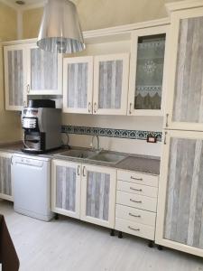 代森扎诺-德尔加达迪塞萨诺德住宿加早餐酒店的厨房配有白色橱柜、水槽和微波炉