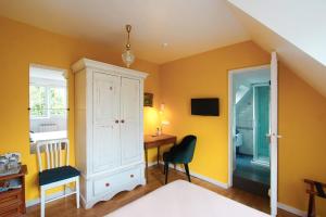 阿斯克新城阿拉梅松都合容酒店的卧室拥有黄色的墙壁,配有桌椅
