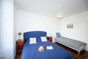 Saint-Dyé-sur-LoireLa Boisselée的一间卧室配有蓝色的床、帽子和毛巾
