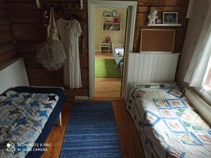 伊萨尔米Laukkumäki farm的一间卧室,卧室里配有一张床,还有一连串挂在房间的连衣裙