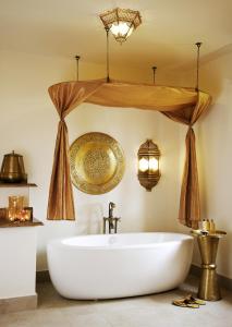 布韦朱巴拉扎桑给巴尔Spa度假村的带浴缸和吊灯的浴室