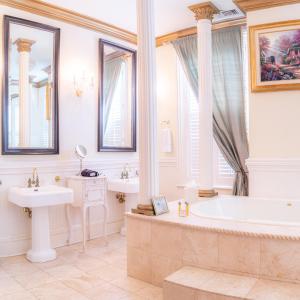 萨凡纳Justine Inn Savannah的浴室配有2个盥洗盆、浴缸和浴缸。