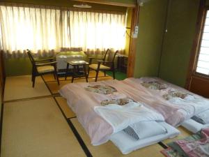 山之内町乌托市旅馆的配有两张床铺的客房配有桌椅