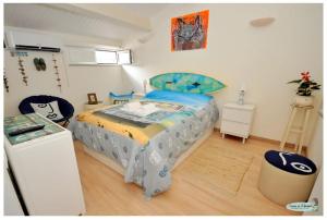 法鲁Casinha da Ti Babel的一间卧室配有一张蓝色和黄色毯子的床