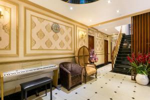 胡志明市Indochine Ben Thanh Hotel & Apartments的一间设有钢琴、椅子和楼梯的房间