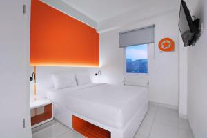 当格浪Starlet Hotel Jakarta Airport的卧室配有白色的床和橙色的墙壁